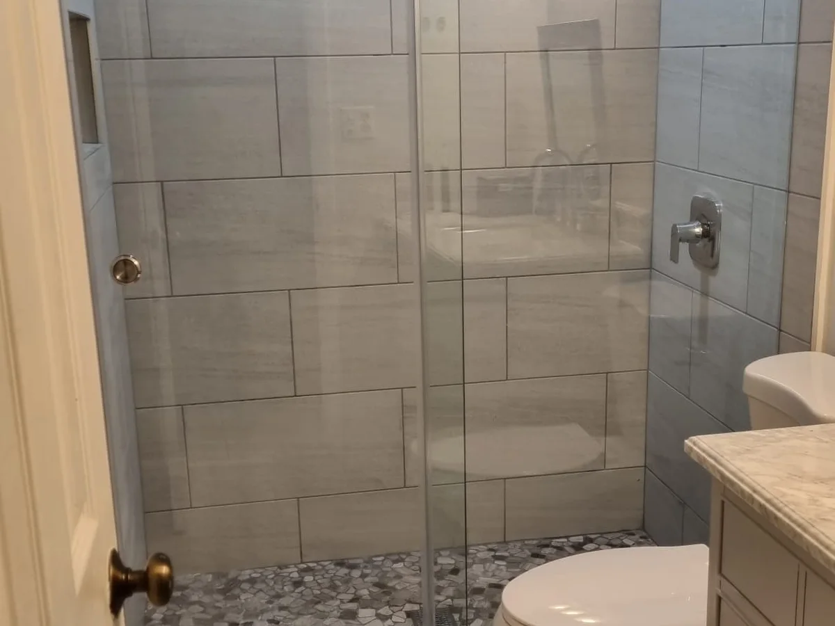 Glass shower with tile and a wood vanity
